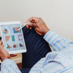Person looking at a tablet with graphs on it
