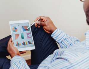 Person looking at a tablet with graphs on it
